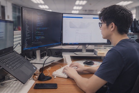 Engineer focused on development work at dual monitors